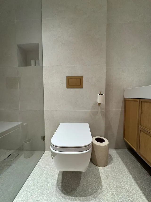 Bathroom with wall-hung toilet, stone-look tile and wall niche