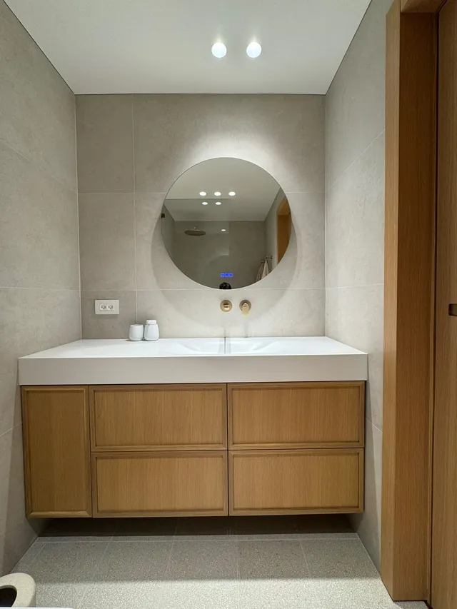 Floating oak vanity with an integrated white basin