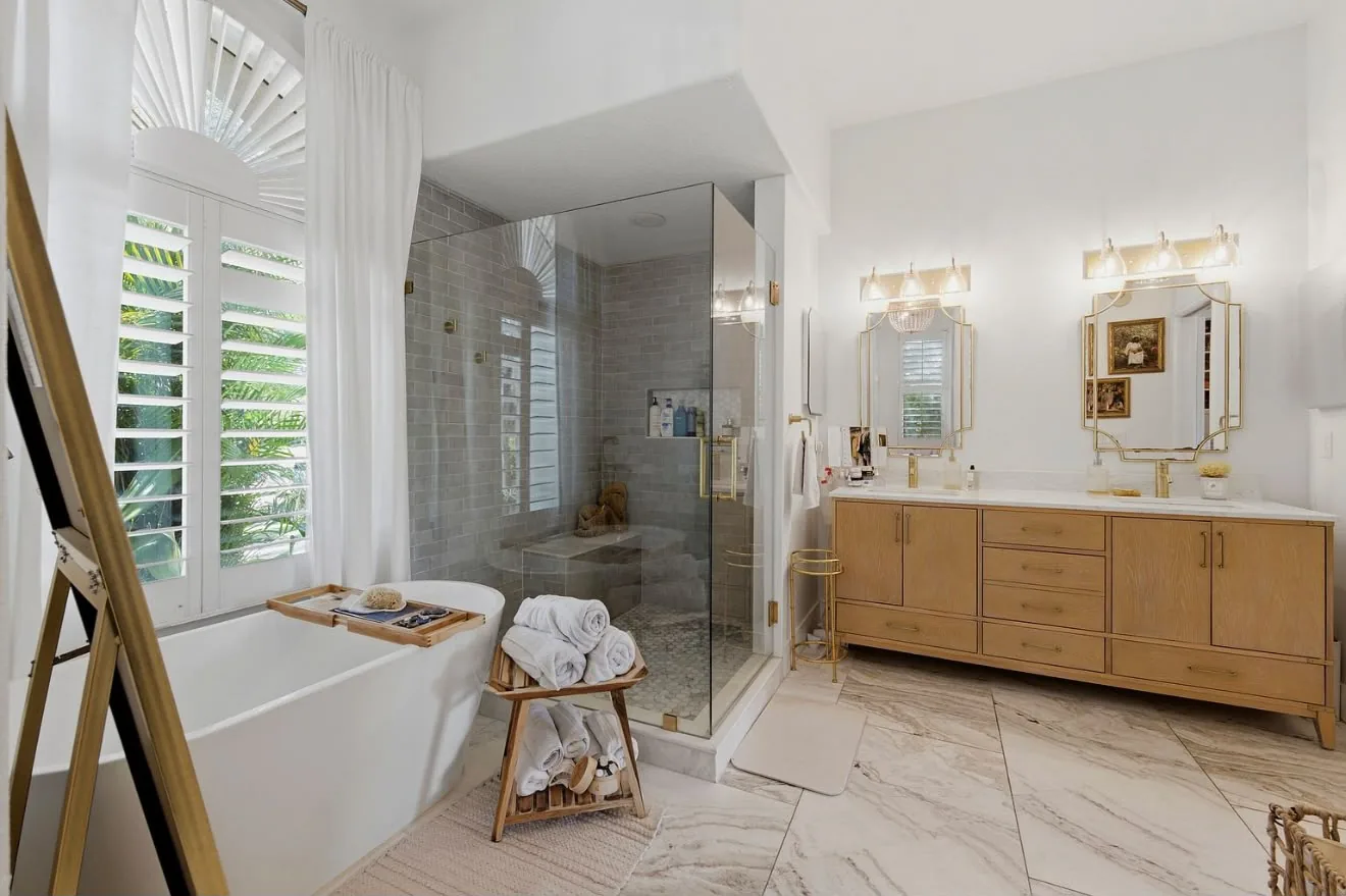 Primary bathroom with a freestanding tub, glass shower and an oak double vanity